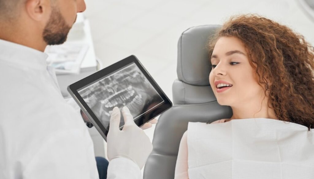 skilled-male-dentist-showing-x-ray-picture-teeth-woman_651396-1393