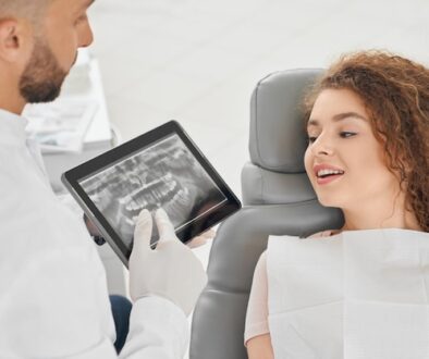 skilled-male-dentist-showing-x-ray-picture-teeth-woman_651396-1393