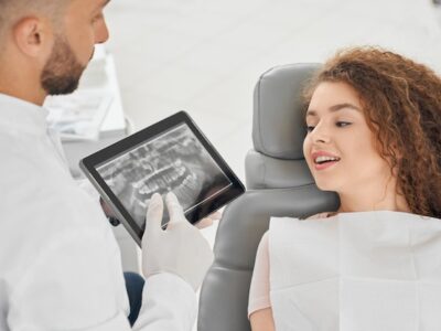skilled-male-dentist-showing-x-ray-picture-teeth-woman_651396-1393